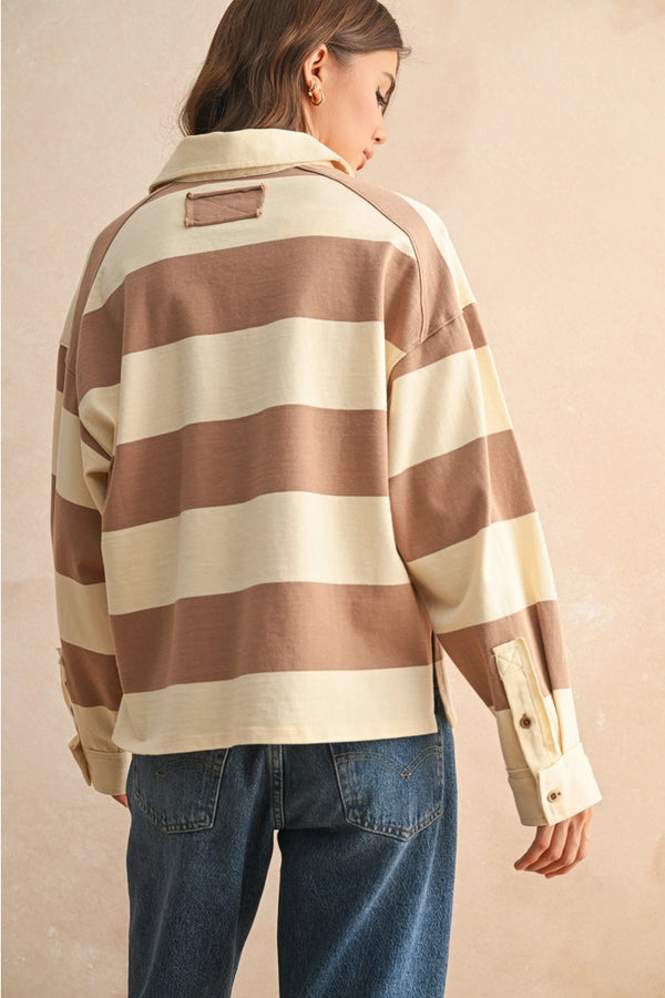 back view of the model wearing the emma long sleeve top. shows the stripes. also shows the button closure on the cuffs, the boxy fit and the mocha and ivory color. 