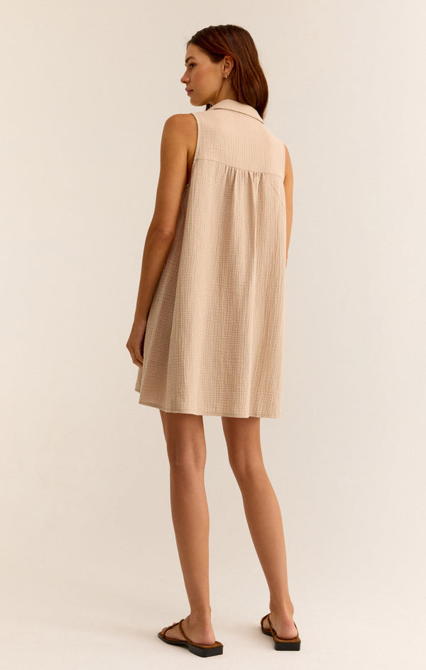 back view of the model wearing the new light mini dress. shows the collared neckline.  also shows the slight pleating and that the dress is sleeveless. 