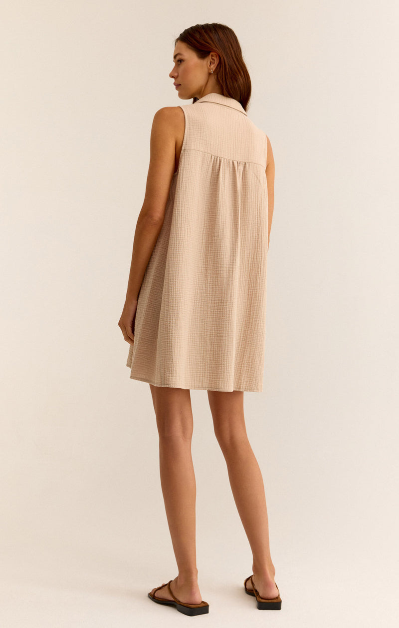 back view of the model wearing the new light mini dress. shows the collared neckline.  also shows the slight pleating and that the dress is sleeveless. 