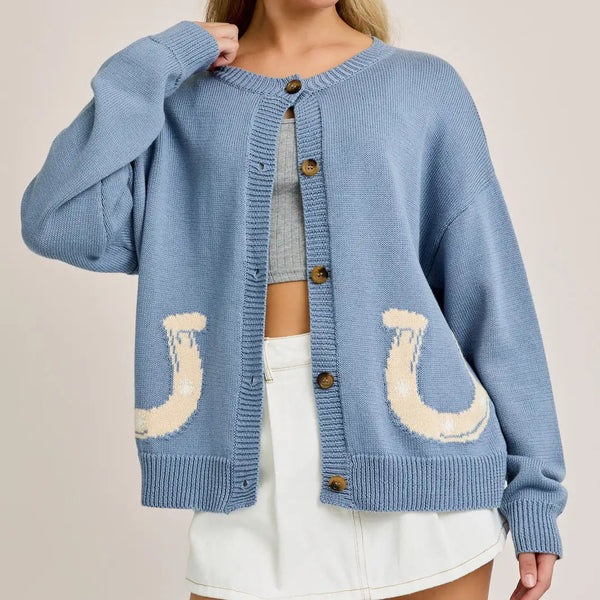 front view of the model wearing the horseshoe cardigan. shows the crew neckline. also shows the button down closure, the ribbed detailing and the horseshoe detailing. 
