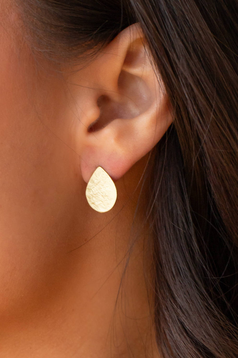 shows the model wearing the gold tear drop shape stud earring.