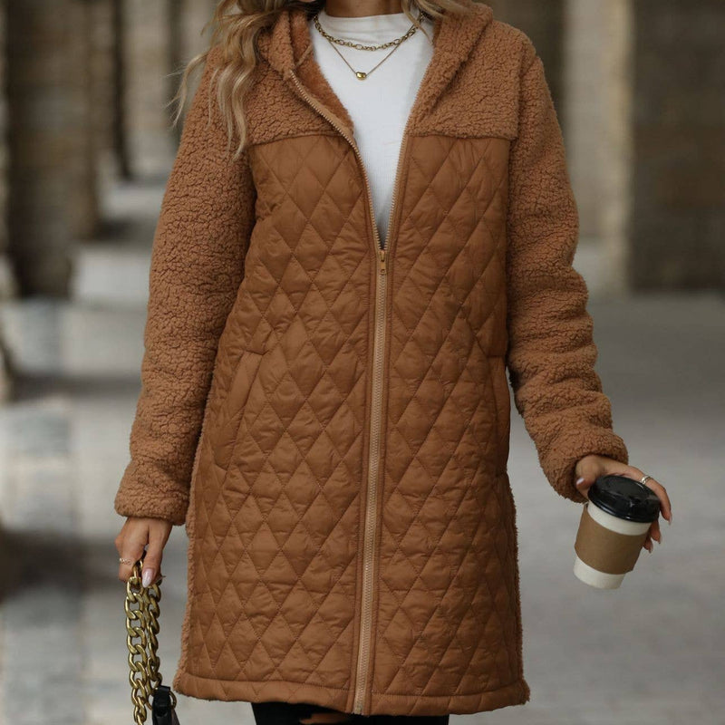 Woman wearing a brown quilted coat holding a coffee cup in an urban setting