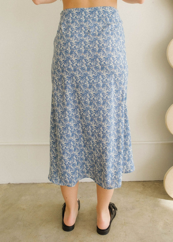 Back view of the model wearing the skirt. Shows the midi length. Also shows the high waisted waist. 