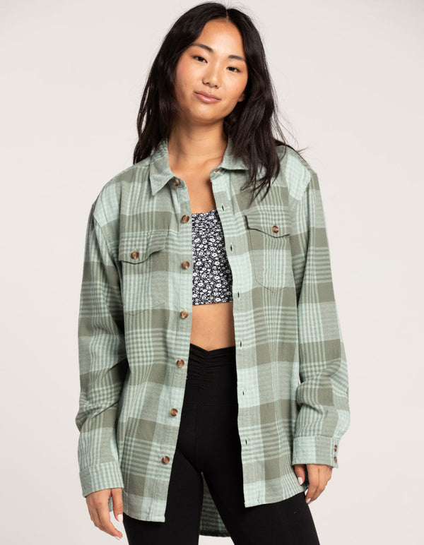 another front view of model in flannel shirt. shows the plaid print, front pouch pockets and oversized fit.