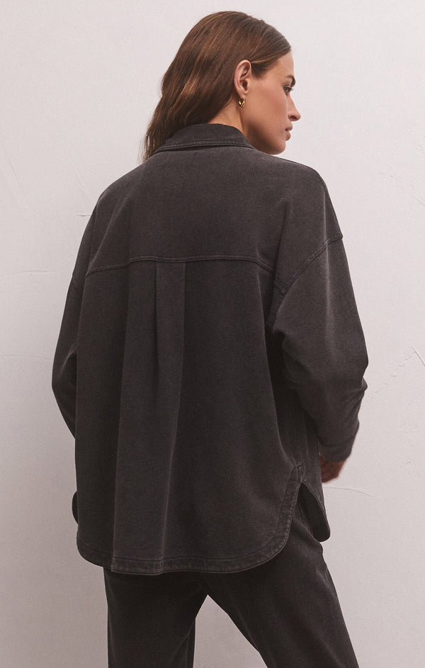 back view of model in jacket. shows the loose fit, dropped shoulders and horizontal seam running across the back.