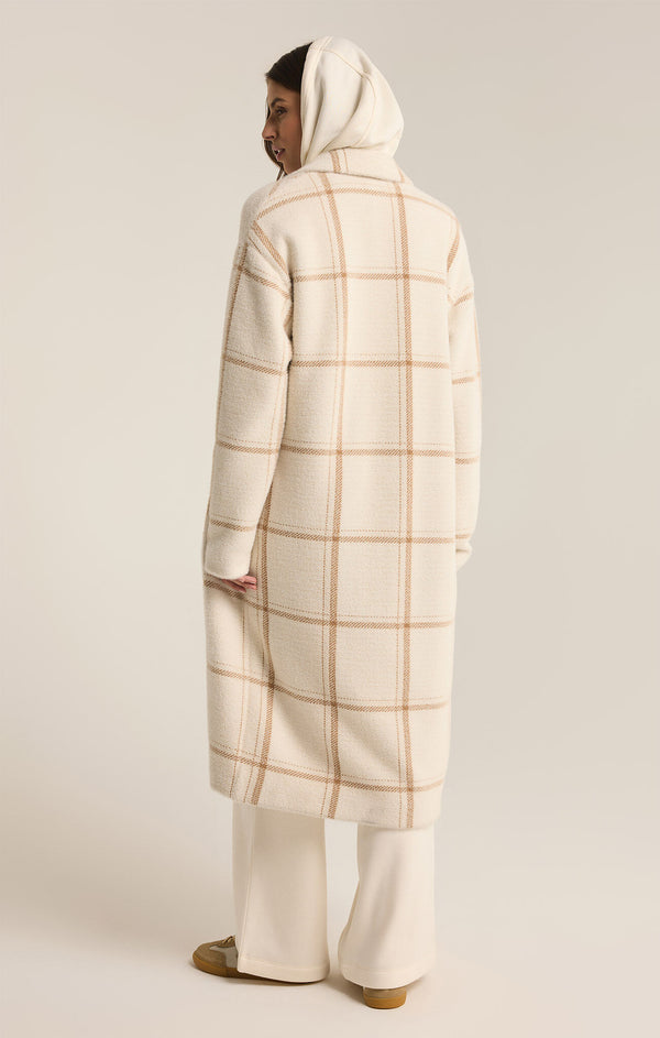 back view of the model wearing the mason windowpane coat. shows the long sleeves. also shows the long length, the collar and the side seam pockets. 