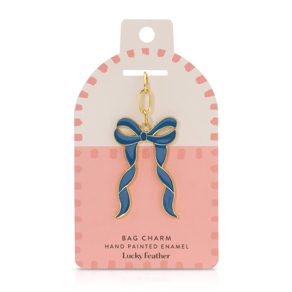 Blue bow bag charm on a pink and white card with 'Lucky Feather' branding.