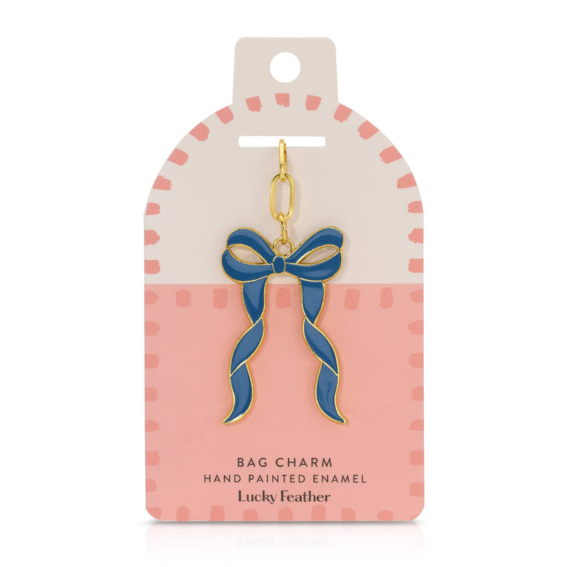 Blue bow bag charm on a pink and white card with 'Lucky Feather' branding.