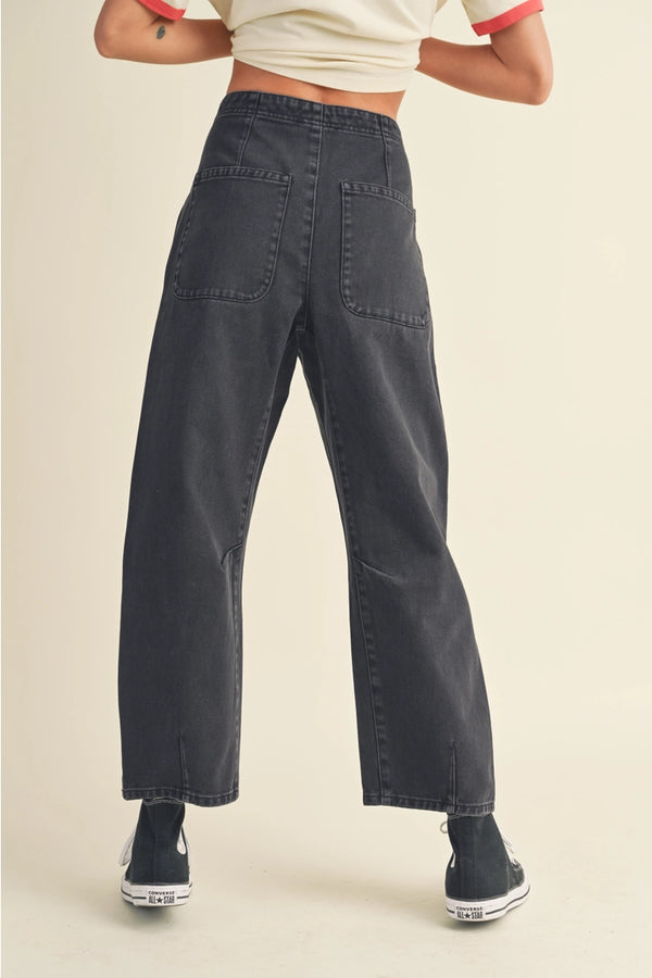 back view of the model wearing the alix washed cotton pants. shows the back patch pockets. also shows the defined seaming throughout, the barrel like style and the defined seaming throughout. 