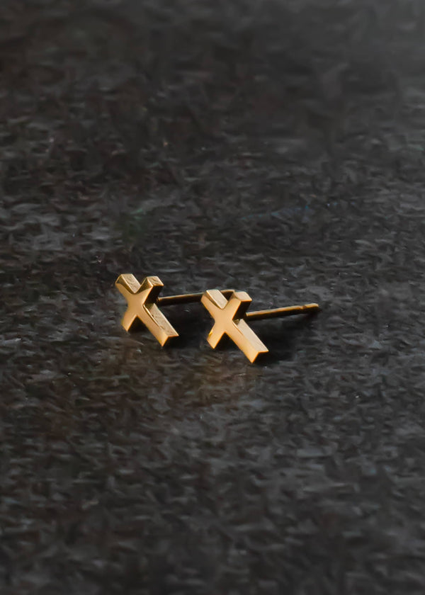 front view of the cross stud earrings. shows the gold cross, and the post. 