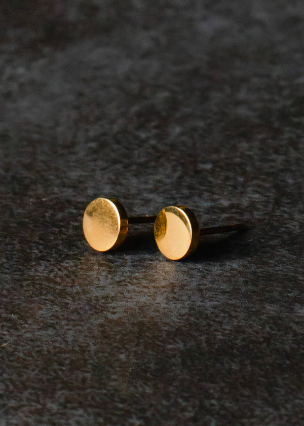 side view of the circle stud in gold. shows the solid round gold circle and the post. 