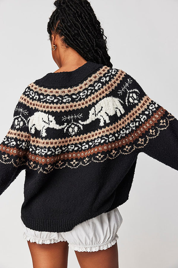 Back view of model wearing sweater. Shows the ribbed hems. Also shows that back is longer than front and scoop neckline. 