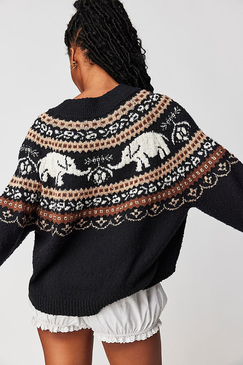 Back view of model wearing sweater. Shows the ribbed hems. Also shows that back is longer than front and scoop neckline. 