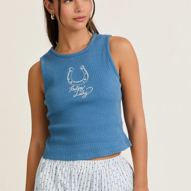 front view of the model wearing the horseshoe tank. shows the blue color of the tank. also shows the embroidered design, the ribbed detailing and the scoop neckline.