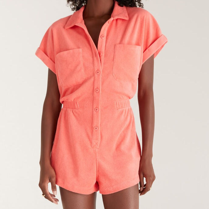 Front view of terry cloth romper. Shows shorts, collared neckline, front chest pockets, and elastic waist detail.