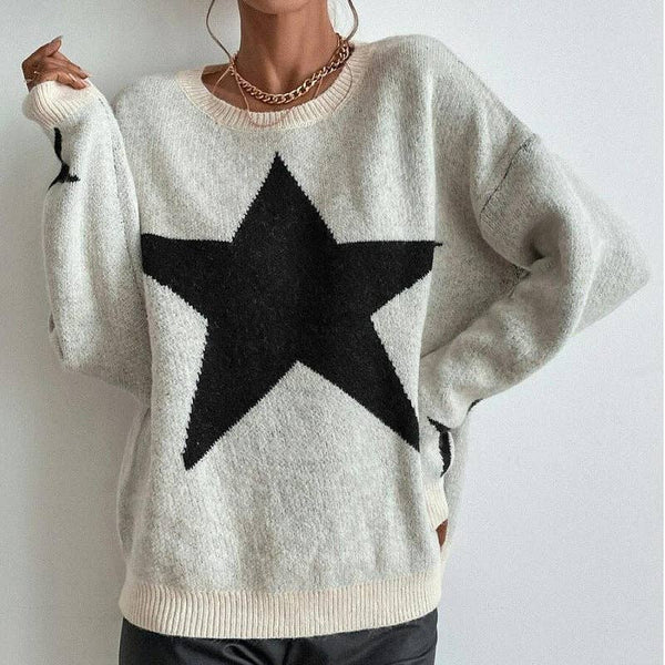 Person wearing a white sweater with a black star design against a plain background