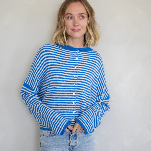 Person wearing a blue and white striped sweater against a plain background