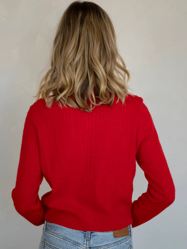 Person wearing a red sweater with a neutral background