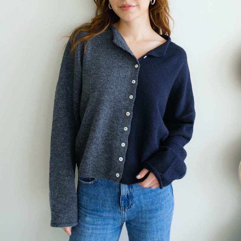 Front view of model wearing cardigan. Shows the button closure. Also shows the oversized fit and color block detailing.