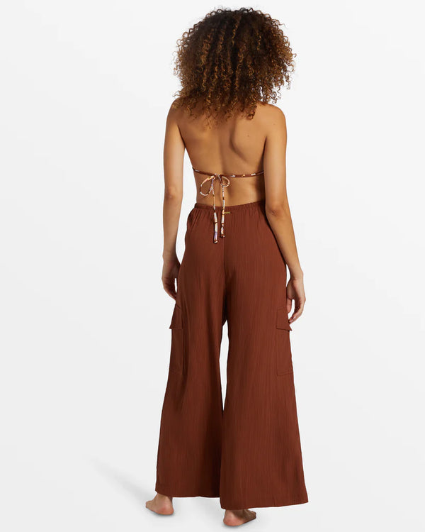 back view of the model wearing the beach babe cargo pant. shows the high waist of the pant. also shows the wide leg and the side cargo pockets on the leg. 