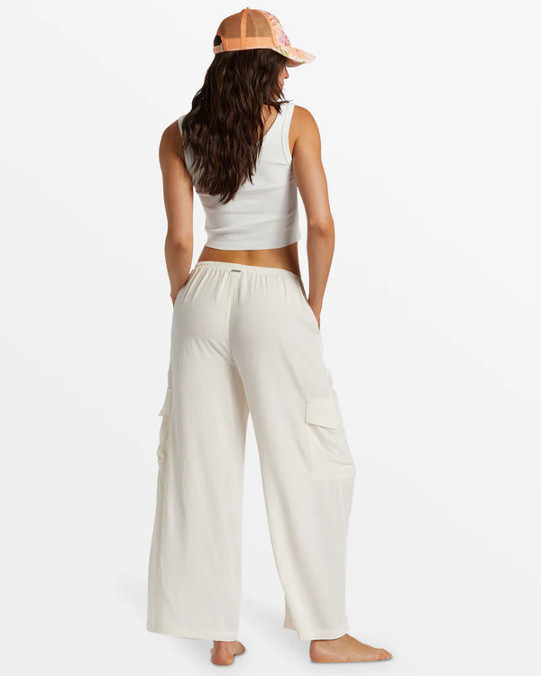 back view of the model wearing the beach babe cargo pant. shows the elastic waistband. also shows the hip and side leg pockets, the wide leg and the relaxed fit. 