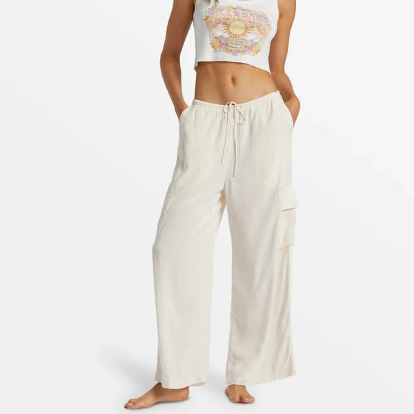 front view of the model wearing the beach babe cargo pant. shows the relaxed fit. also shows the elastic waist w/ the tie, the hip and leg pockets, and the wide leg.