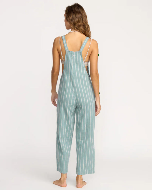 Woman wearing a green and white striped overalls on a white background