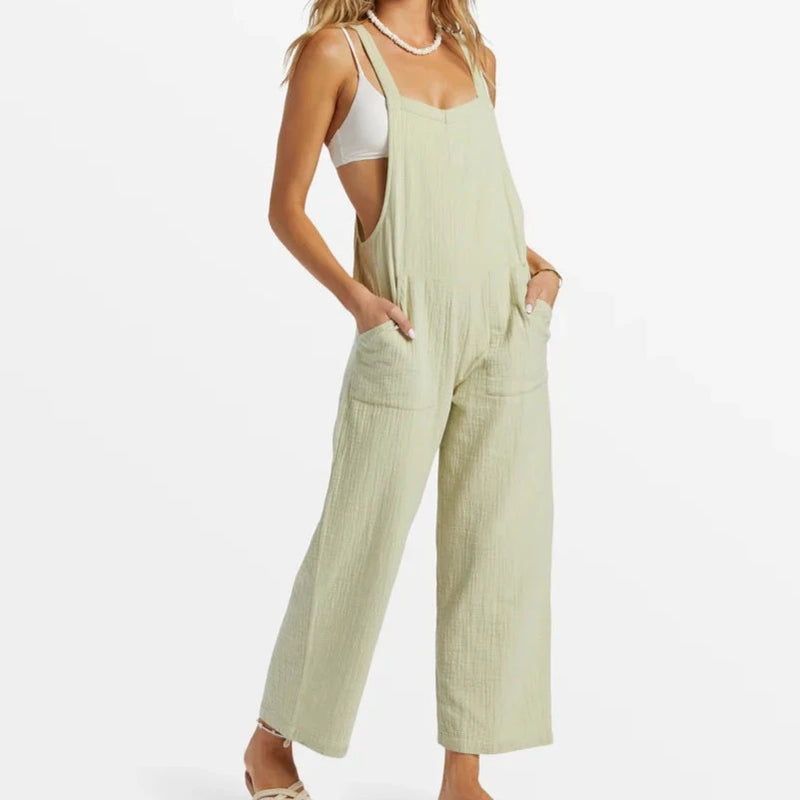 front view of the model wearing the pacific time jumpsuit. shows the straight across neckline. also shows the front patch pockets, the relaxed fit, and the straight legs. 