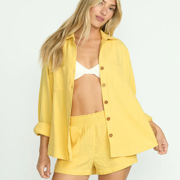 front view of the model wearing the sweet swell long sleeve shirt. shows the collar. also shows the button down closure, the patch pockets and the oversized fit. 