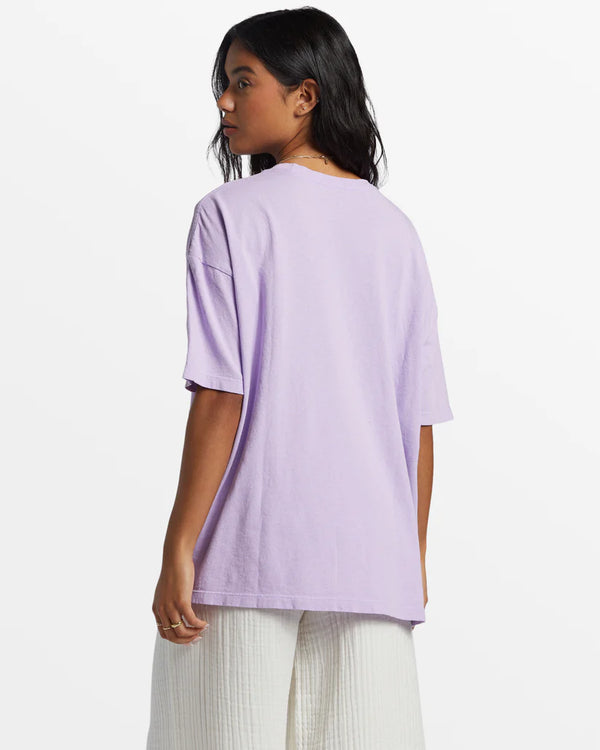 back view of the model wearing the surf trip oversized t shirt. shows the dropped shoulders. also shows the oversized fit and the loose crew neckline. 