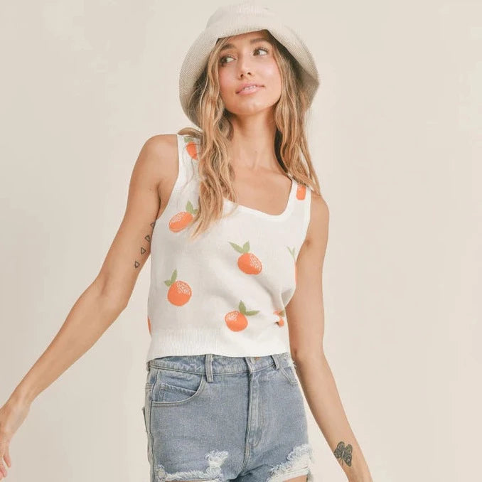 front view of sweater tank. has a square neckline. thick fixed straps, and all over oranges print.