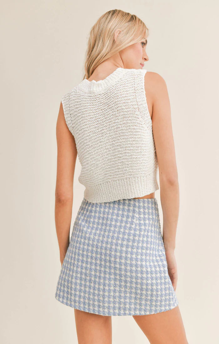 shows back of model. here you can see the cropped length, open knit fabrication, and high neck.