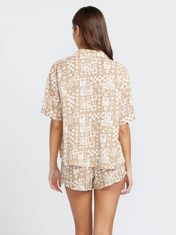 back view of the model wearing the sunny daze shirt. shows the all over print. also shows the side slit detailing and the collar. 
