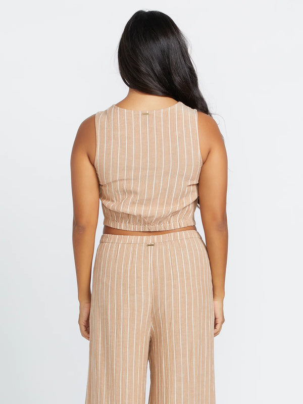 back view of the model wearing the coco ho vest. shows the back elastic bottom. also shows the pinstripe print and the cropped length of the vest. 
