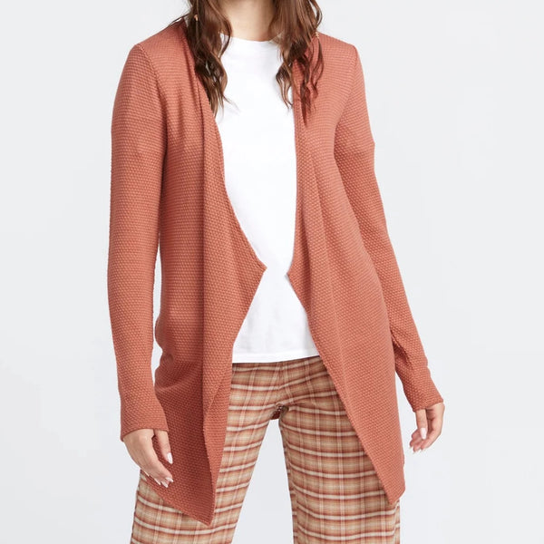 front view of the model wearing the go go wrap cardigan. shows the textured detailing throughout. also shows the open front, the long sleeves and the waterfall like front of the cardigan. 