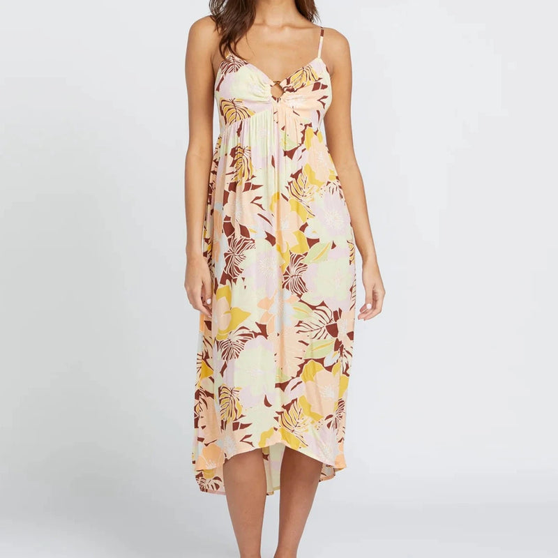 front view of the model wearing the oh lei maxi dress. shows the high-low hemline. also shows the all over print, the ring sewn in the center and the spaghetti straps. 