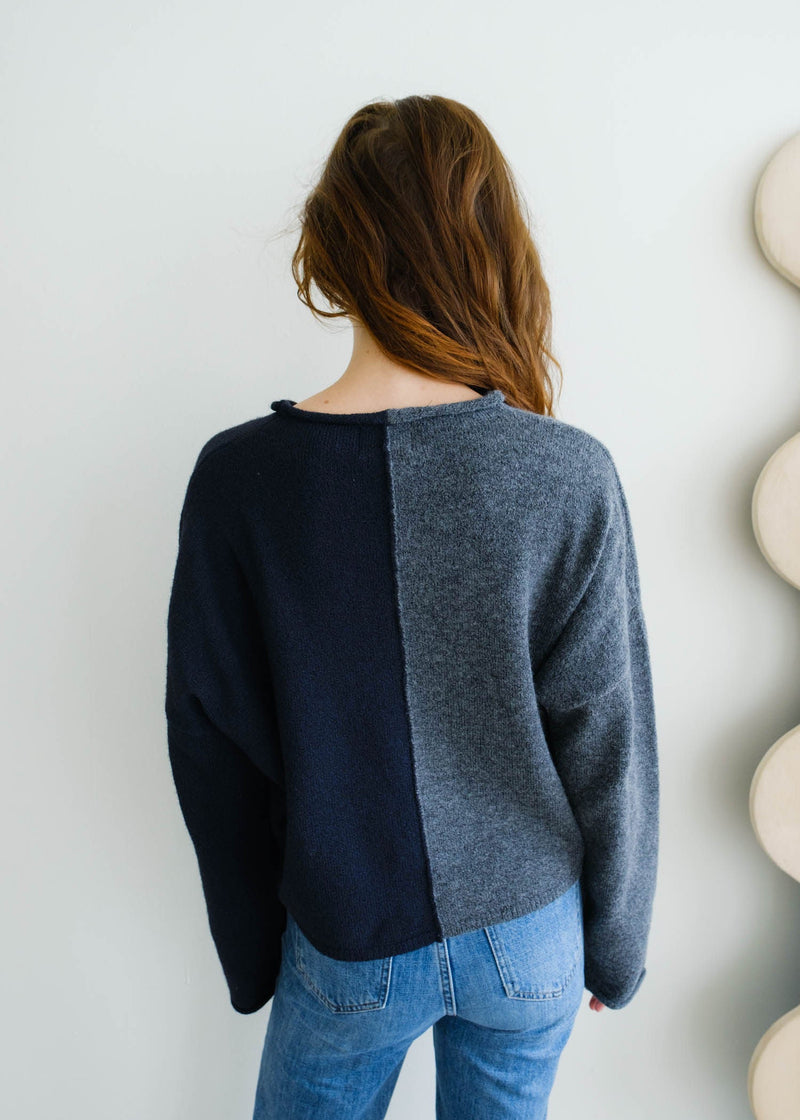 Back view of model wearing cardigan. Shows the color block detailing. Also shows the drop shoulder seams. 