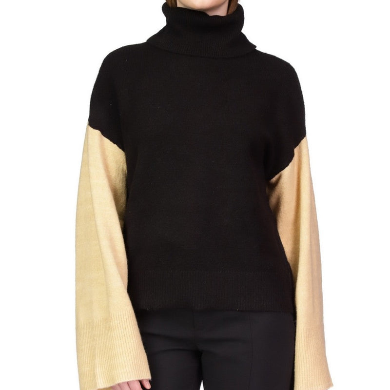 Front view of model wearing sweater. Shows turtleneck. Also shows colorblock and bell sleeves. 
