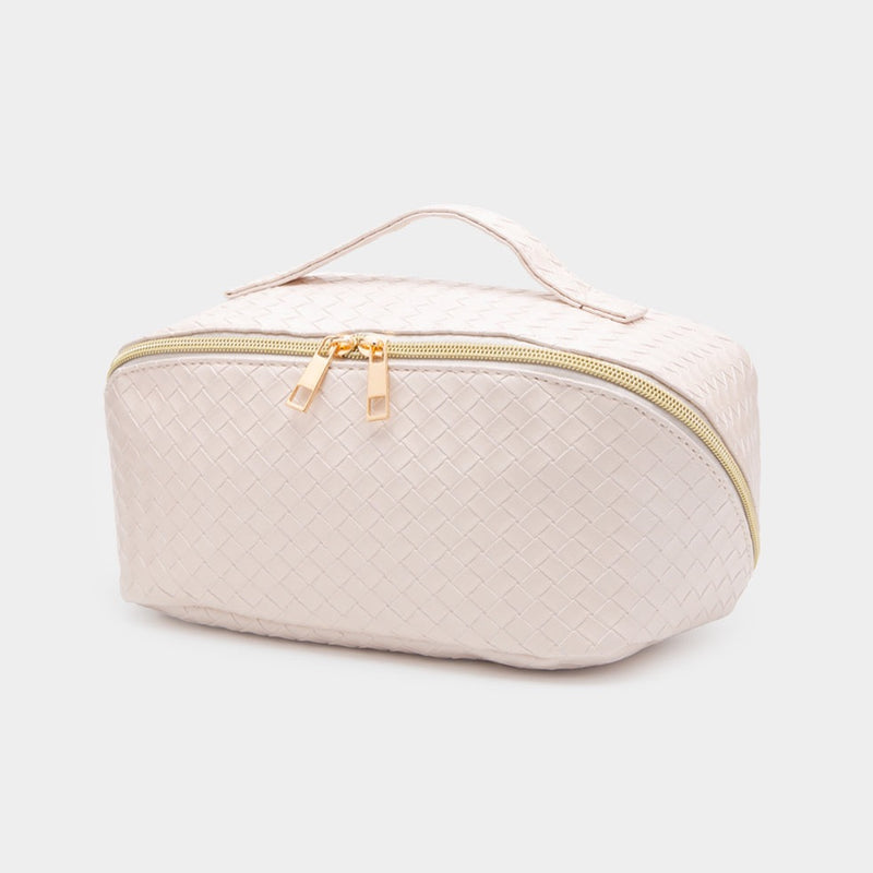 Front view of cosmetic bag. Shows the woven detail. Also shows the zipper closure. the gold hardware and the ivory color.