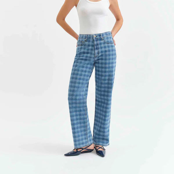 Woman wearing blue checkered pants and a white tank top on a white background