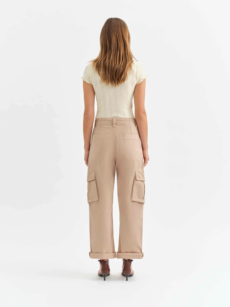 back view of the model wearing the squad curved leg cargo pant. shows the multiple pockets. also shows the rolled cuff and the taupe color. 