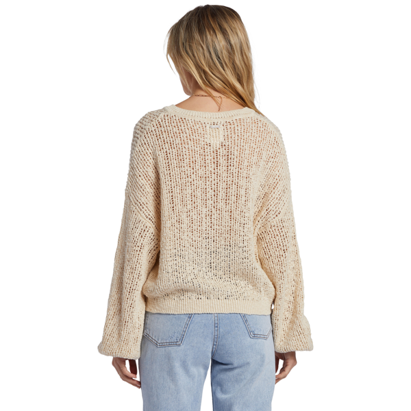 back view of the model wearing the warmin up sweater. shows the dropped shoulders. also shows the oversized sleeves, the boxy fit and on the model it hits her alittle below the waist. 