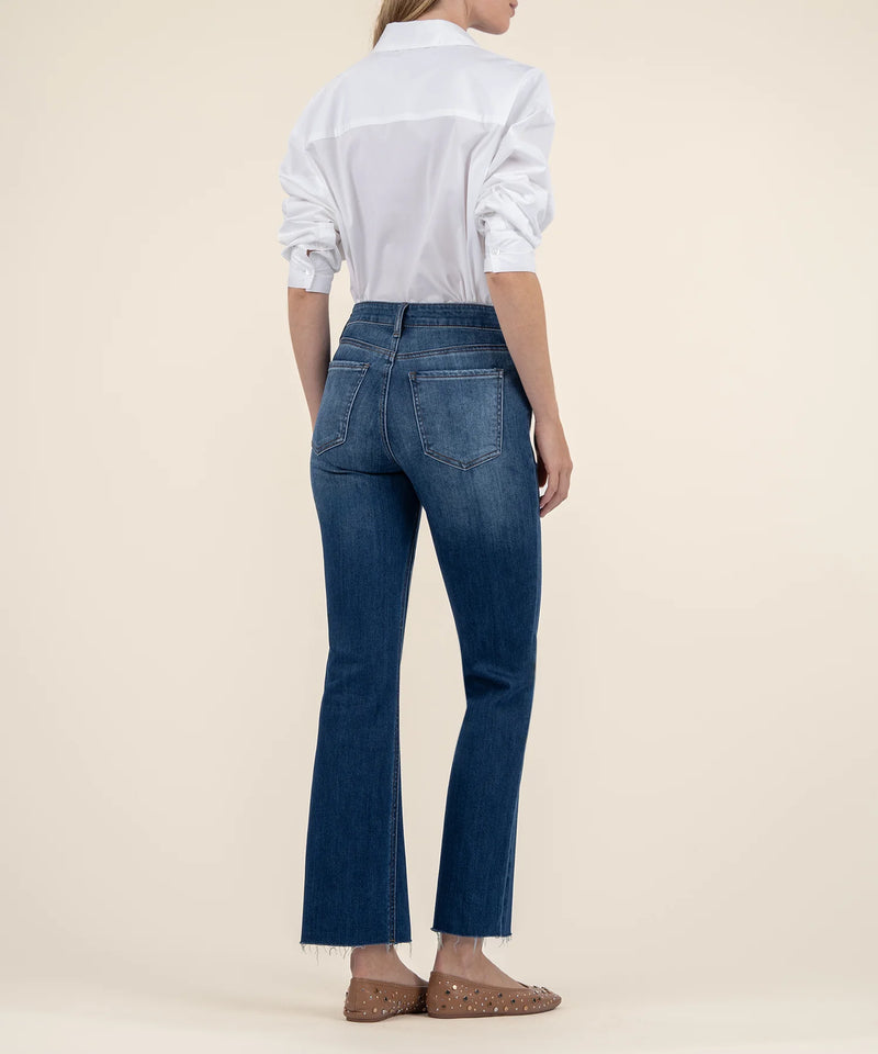 Person wearing blue jeans and a white shirt on a beige background
