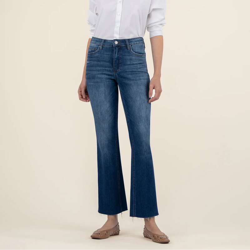 Woman wearing a white shirt and blue jeans on a beige background