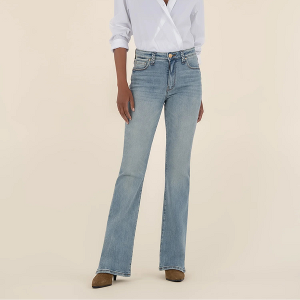 Person wearing a light blue shirt and jeans on a beige background