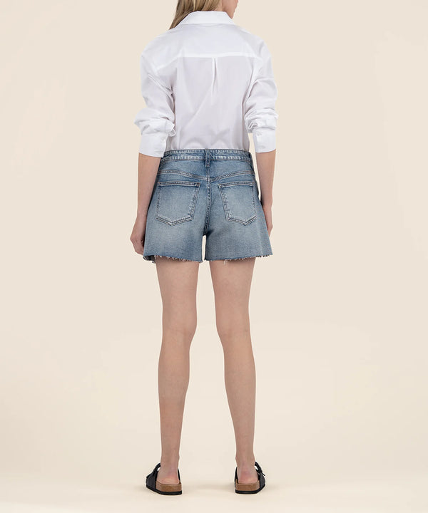 back view of the model wearing the taylor high rise shorts, shows the back pockets. also shows the raw hem, the belt loops.
