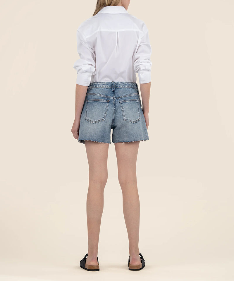 back view of the model wearing the taylor high rise shorts, shows the back pockets. also shows the raw hem, the belt loops.