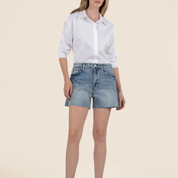 front view of the model wearing the taylor high rise short. shows the raw hem. also shows the high waist, the button/zipper closure and the pockets.
