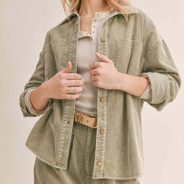 Front view of model wearing shacked. Shows the button front. Also shows the front pockets, collar and the sage corduroy detail. 