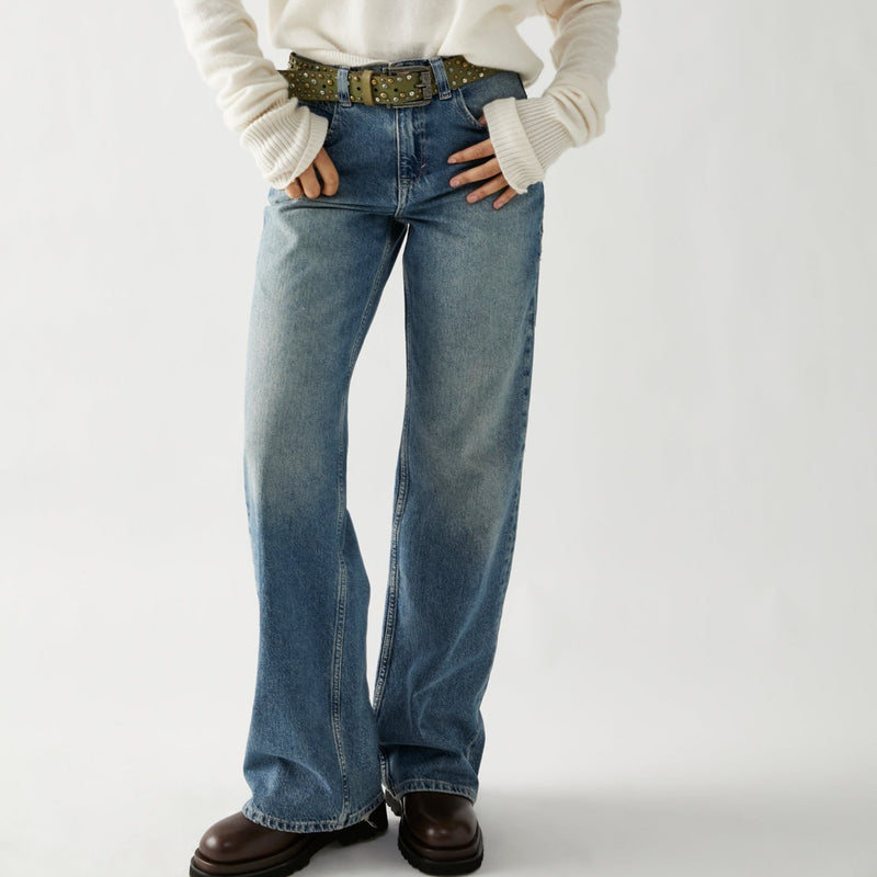 front view of model in the jeans. shows the baggy fit, front pockets and long length. model has them paired with a belt.